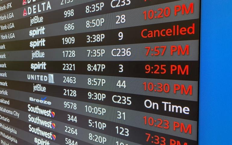 The board showing flight status as cancelled at the airport