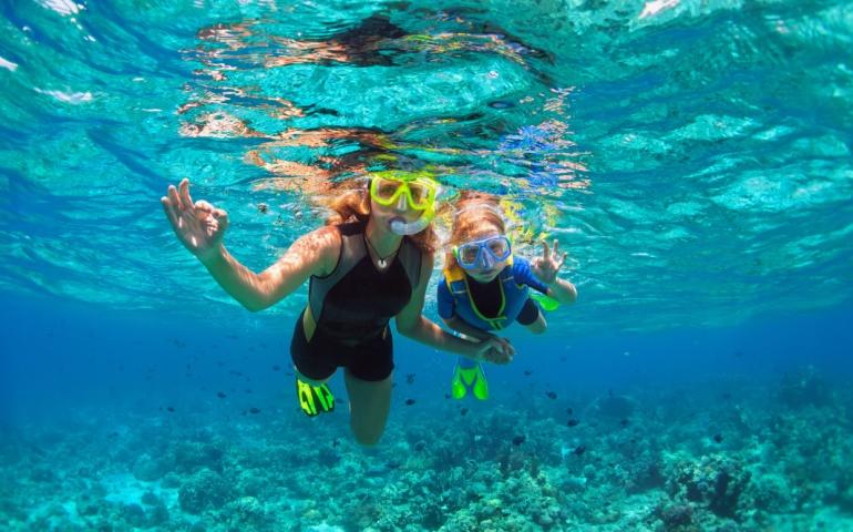 Mother and a kid snorkeling underwater