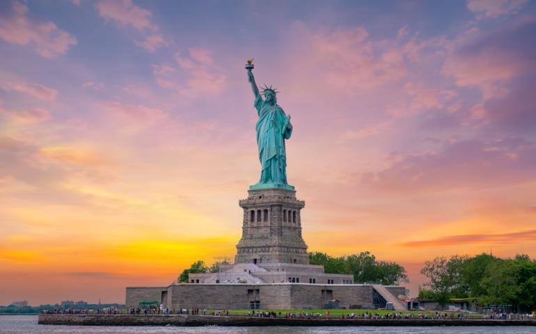 Statue of Liberty at sunset and Manhattan skyline, New York City