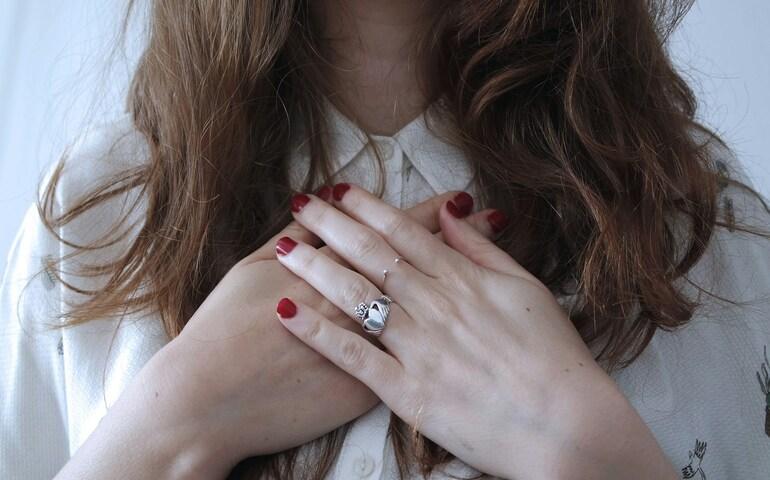 A woman practicing breathing exercises by placing her hand on her chest