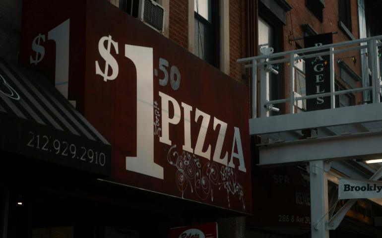 Downtown $1 Pizza Shop Sign on City Street