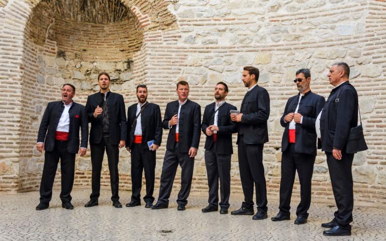 Traditional dalmatian singers , performing under the cathedral dome in Split