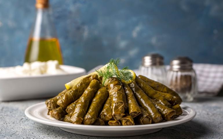 Delicious dolma (sarma) stuffed grape leaves, rice, and white yogurt sauce
