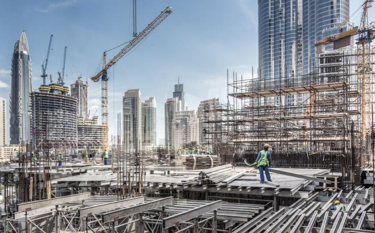 Laborers working at modern construction site in Dubai