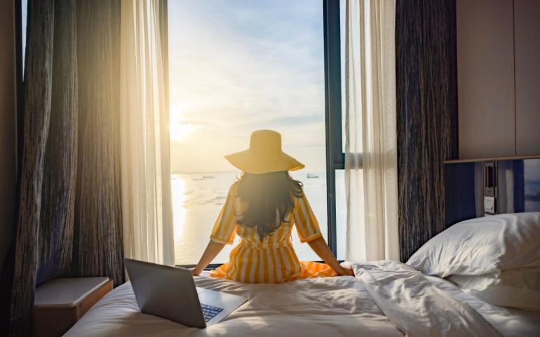 Woman sitting comfortably on her hotel bed