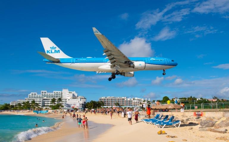 KLM Airplane flying over Maho Beach before landing 