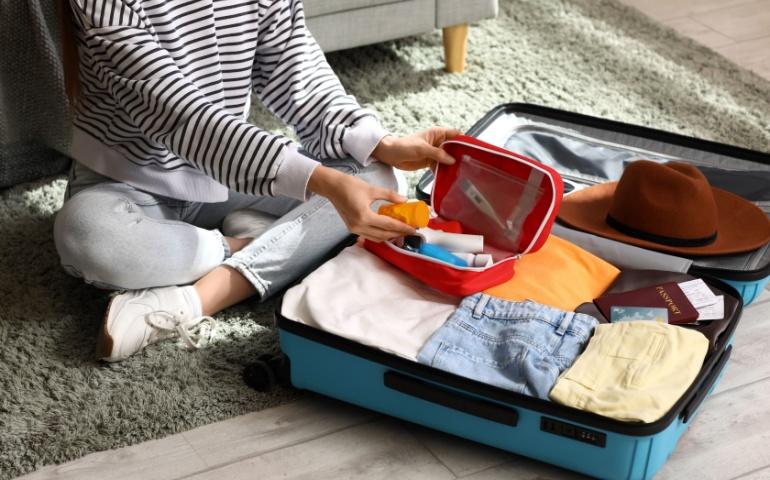 Young Woman Packing Suitcase
