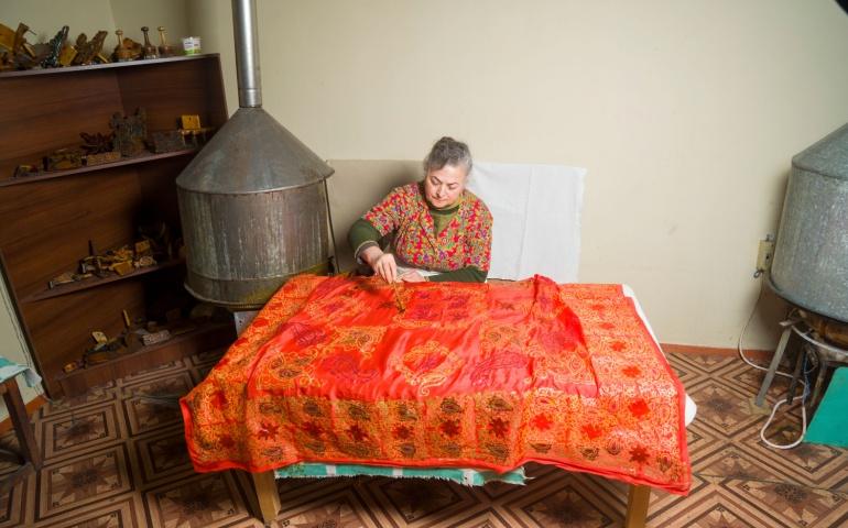 Woman weaving a traditional silk scarf
