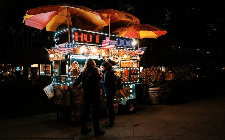 People Enjoying Hot dogs in NY city at Night