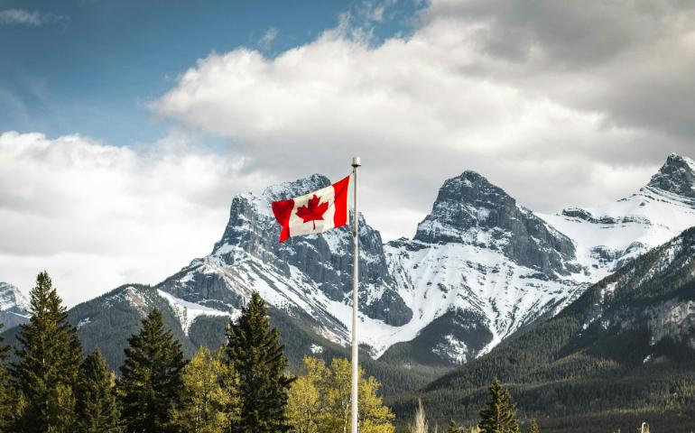 Canadian Flag with Three Sisters in the Background