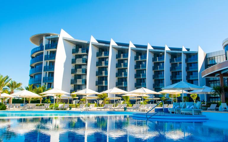 Pool area with sunbeds and umbrellas in luxury hotel in Saadiyat island