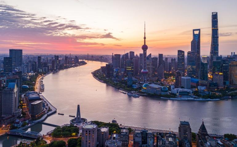 Aerial view of modern city skyline and buildings at sunrise in Shanghai.
