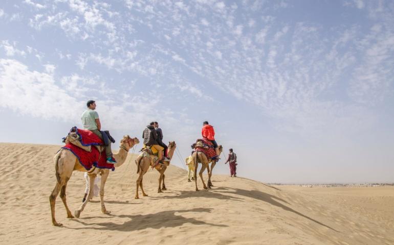 Family riding camels in the Rajasthan desert