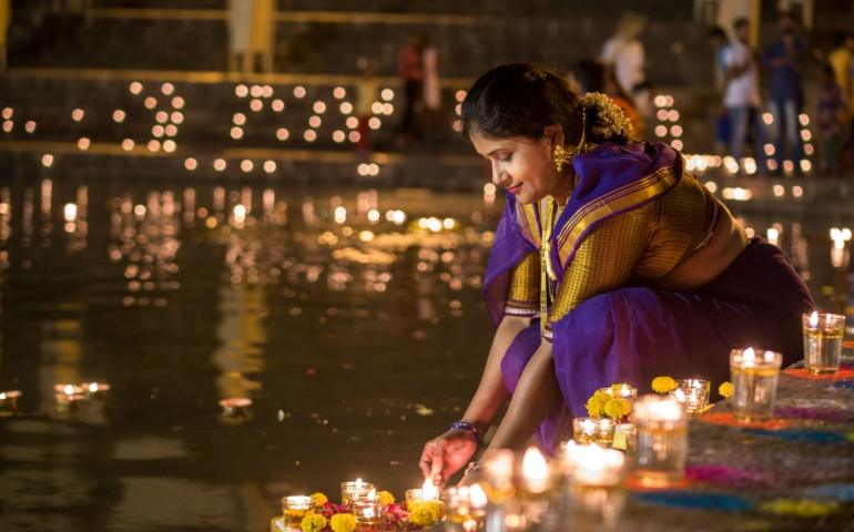 Woman lighting diyas during Diwali