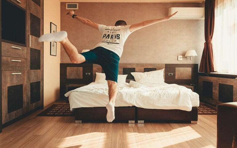A man jumping on the bed