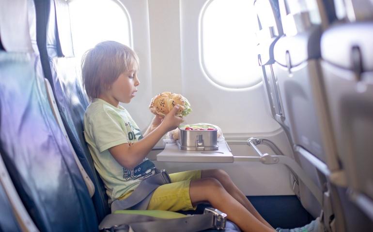 Toddler eating from their tiffin box on the flight