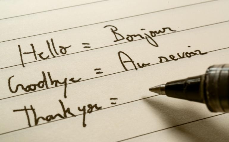 Beginner French language learner writing words in French 