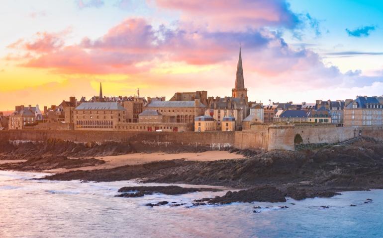 Beautiful view of walled city Saint-Malo with St Vincent Cathedral at sunrise at high tide, France