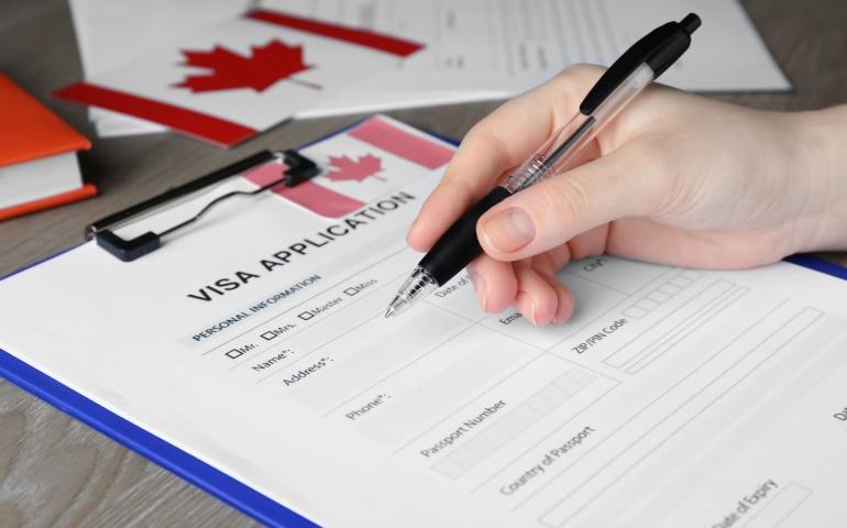 Woman filling visa application form to Canada