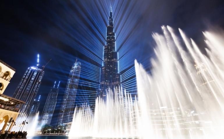 Burj Khalifa lit up with the Dubai Fountain show in Downtown Dubai, UAE, at night