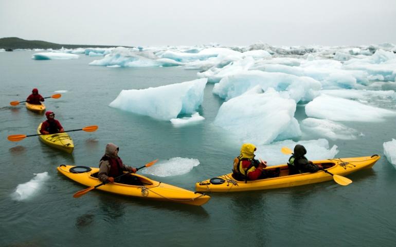 Ecotourists kayak among ice chunks near Whittier in Prince William Sound, Alaska
