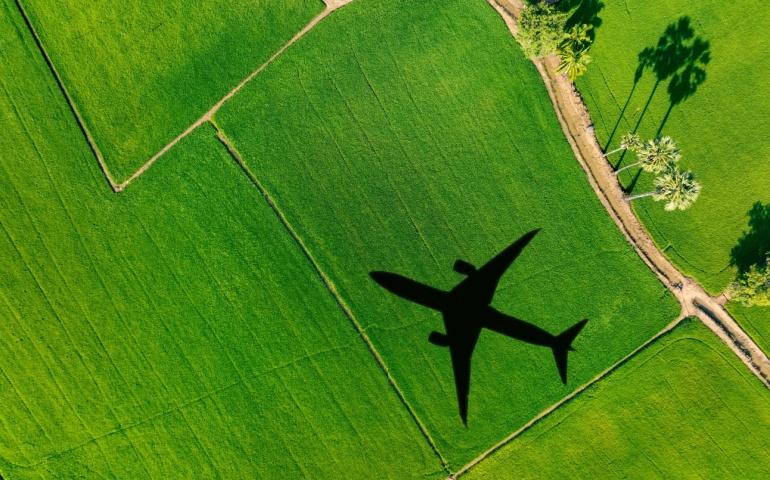 A shadow of a plane falling over green fields