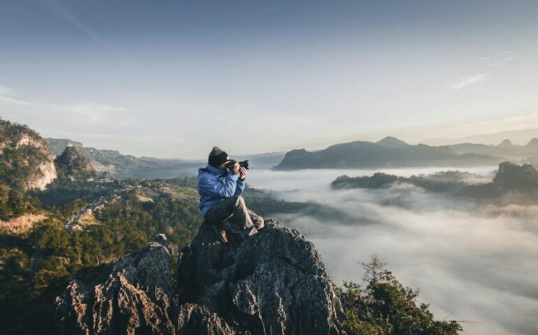 Traveller clicking photos at the top of a mountain
