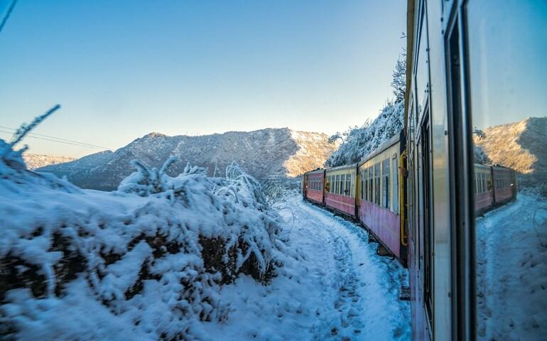 Train driving through the snow