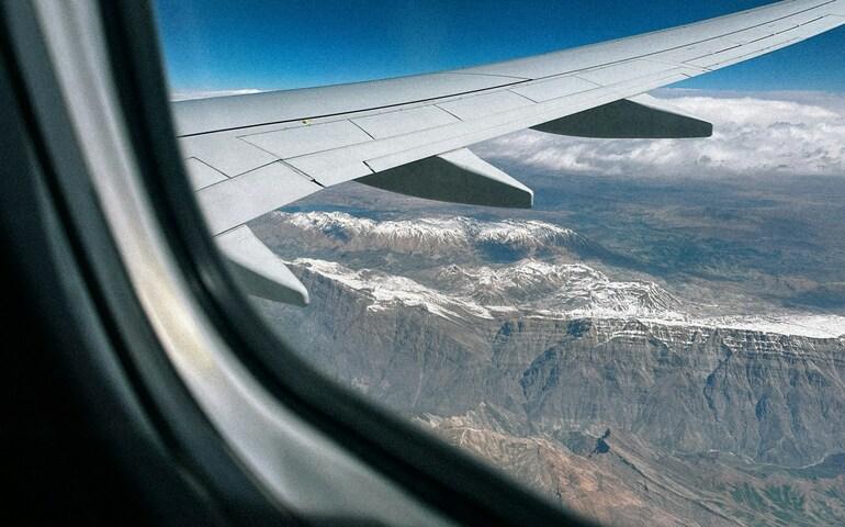 Airplane window view from behind the wing seating