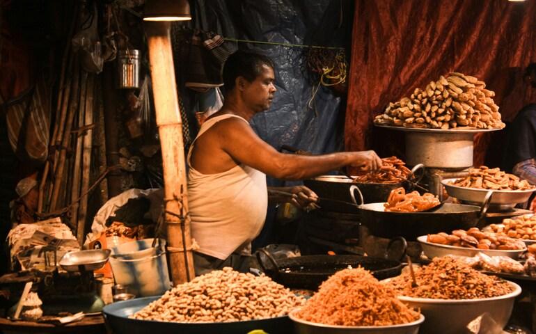 A man standing in front of a table filled with lots of food
