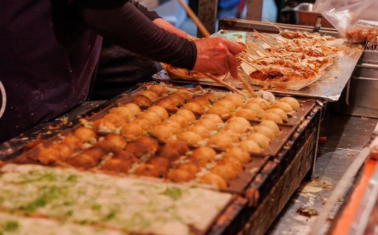 Takoyaki, a popular street food, being prepared at a festival in Japan