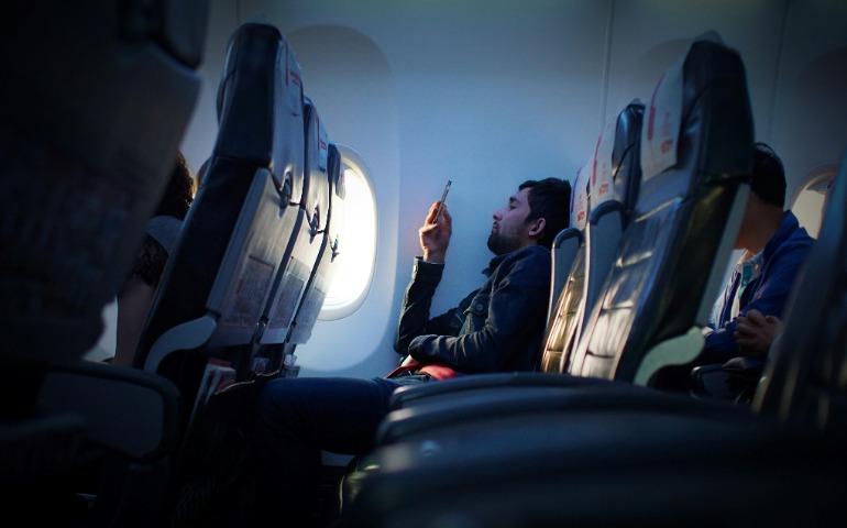 Person checking his phone on plane
Image Credit: Javier Cañada/Unsplash