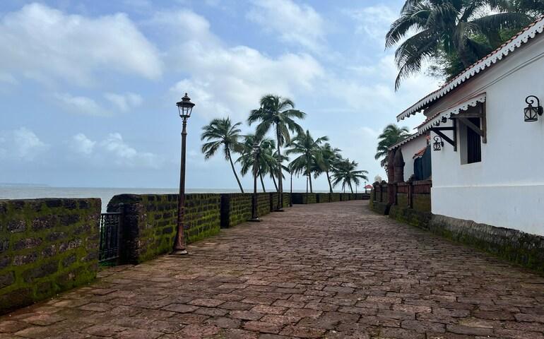 A Cobblestone Road Leading to a White Building

