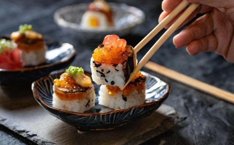 A tourist trying Japanese Sushi in a restaurant in Japan