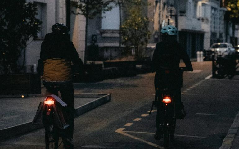 Two people cycling on an empty street
