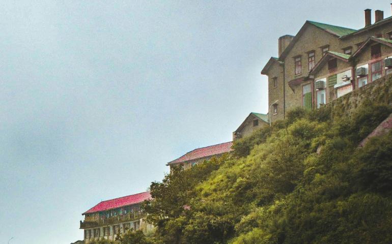 A large building sitting on top of a lush green hillside
