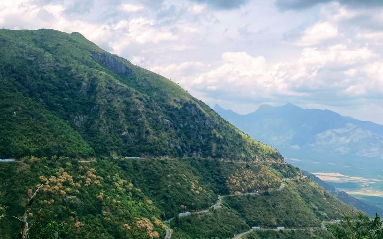 a scenic view of a winding road in the mountains