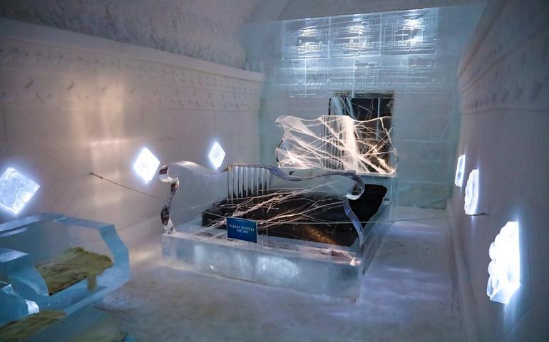 A large, beautiful ice double bed inside one of the rooms at the world-renowned Icehotel
