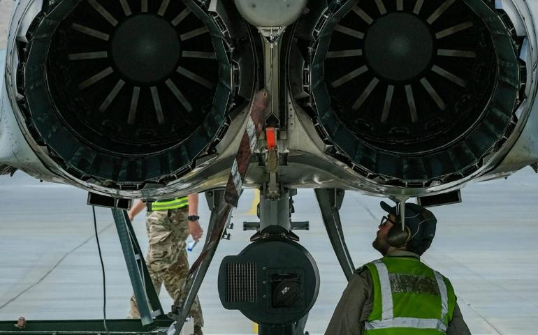 A Man Sitting Under Aircraft Engine