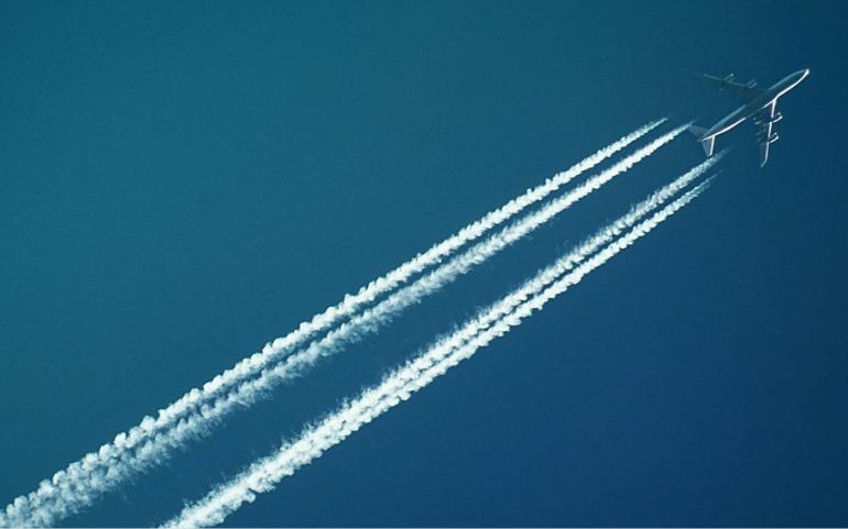 White Airplane with Smoke under Blue Sky