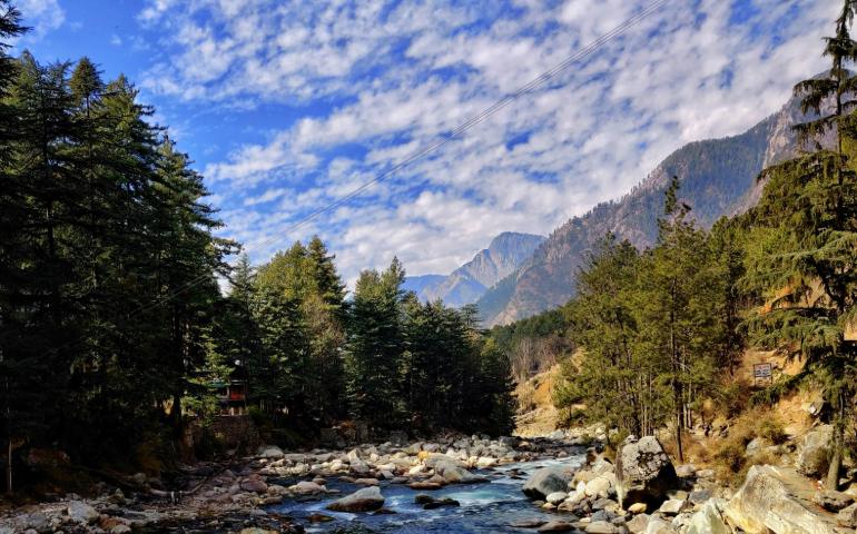 river in between green trees and mountains during daytime
