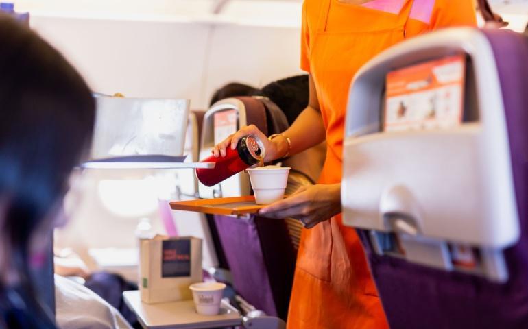 A flight attendant serving drinks to passengers on board