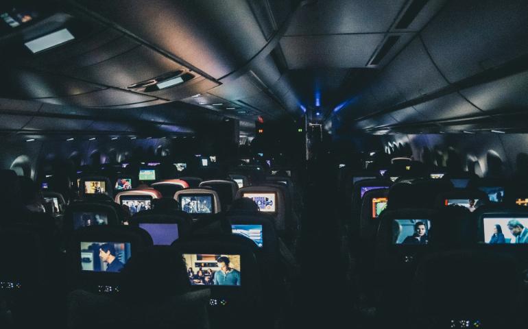 People Enjoying Entertainment on the Screens in Flight
