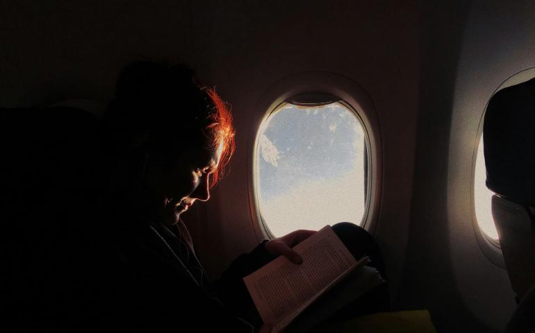 Woman Reading a Book in Airplane