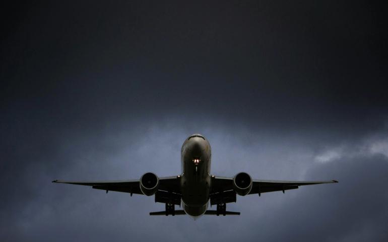 An airplane flying through cloudy sky