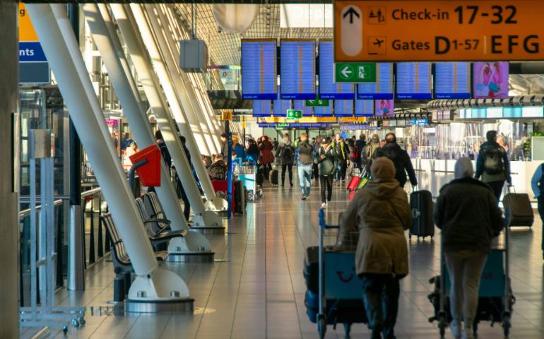 People walking in the check-in hall at Schiphol airport
