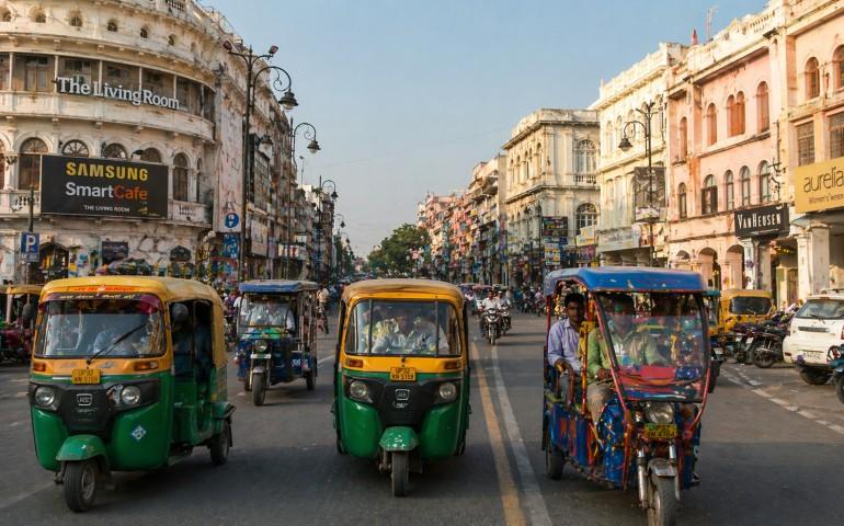 A street scene of colorful rickshaws and colonial buildings
