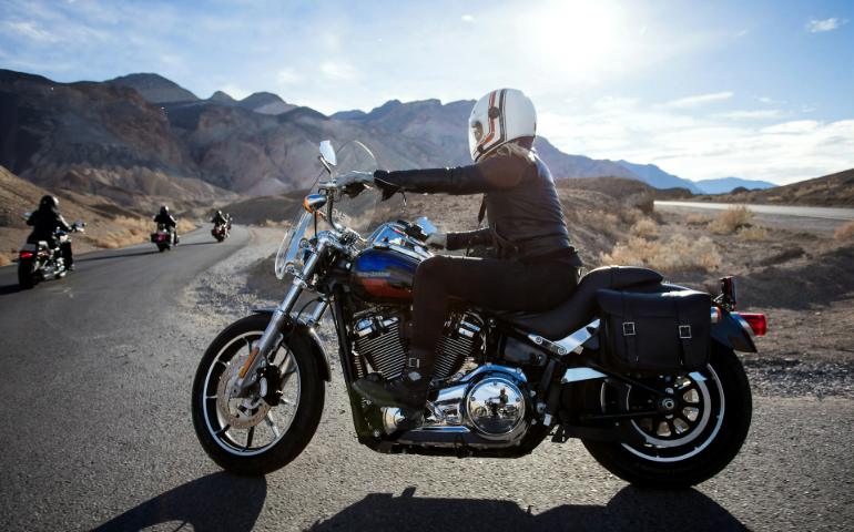 Woman driving a motorbike on a hill