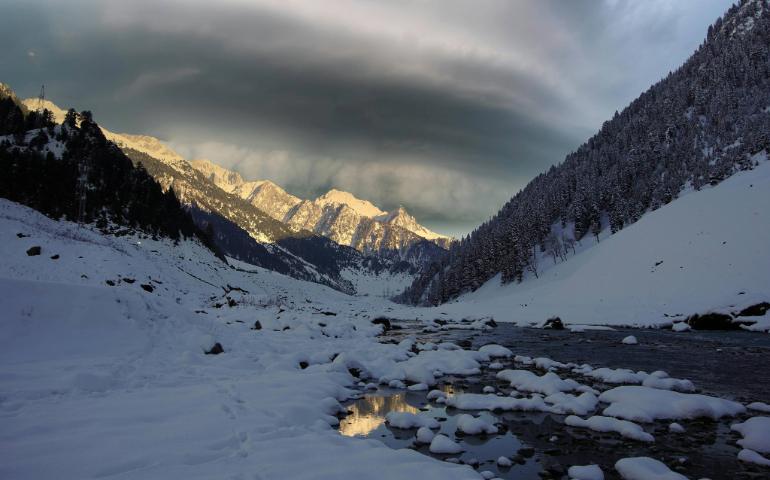 Snow-covered Mountains and Serene River in Sonamarg, Kashmir During Winter