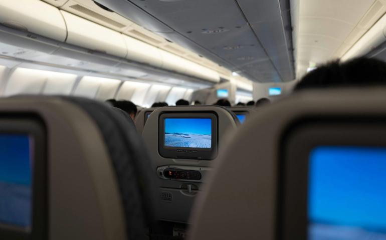 Interior of an Airplane Displaying In-Flight Entertainment Screens and Passenger Seats